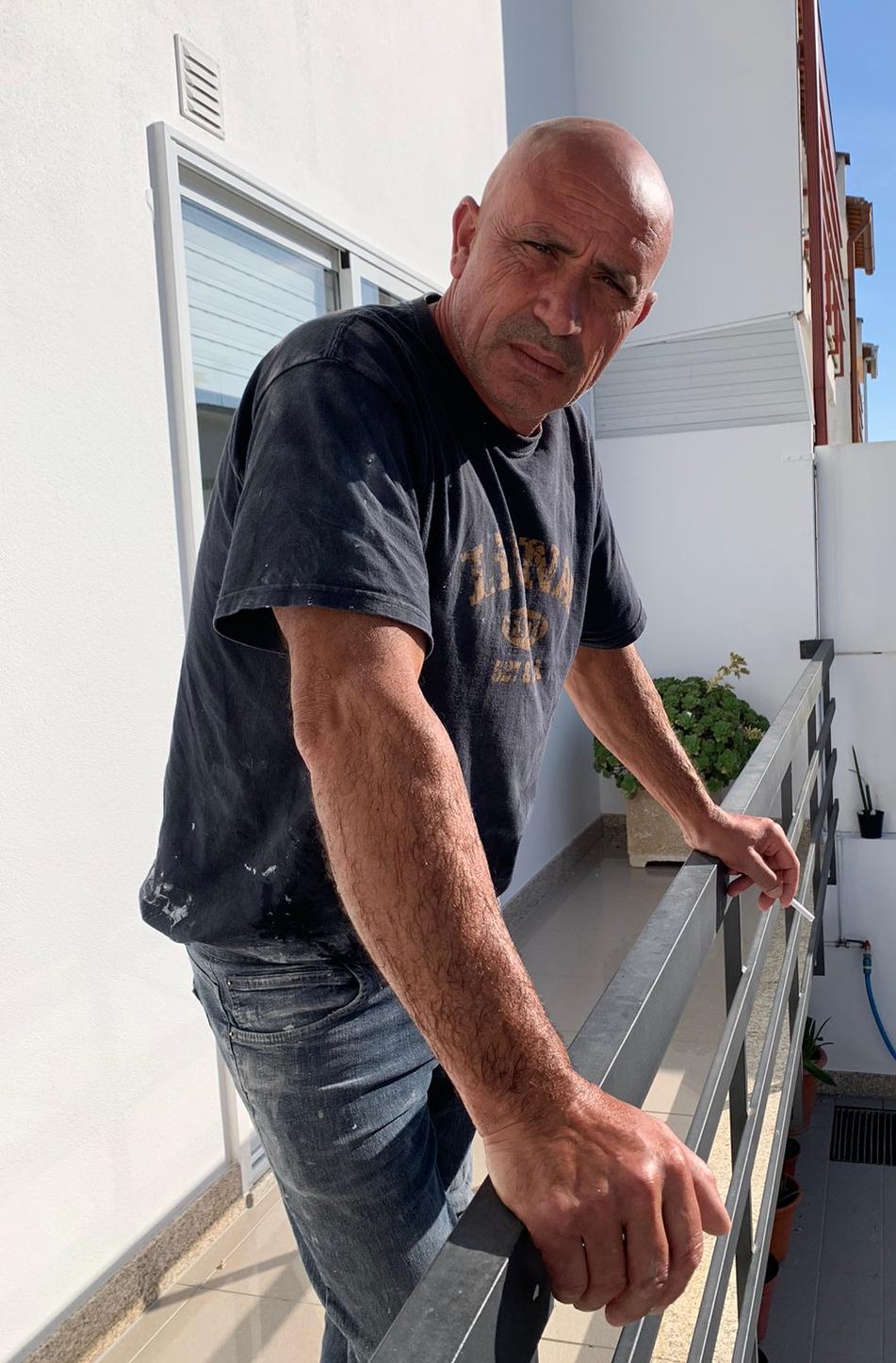 Imagem 4: Fernando Gomes após um dia de trabalho fuma um cigarro na varanda de sua casa para relaxar/ Juliana Gomes/ Barcelos/2024